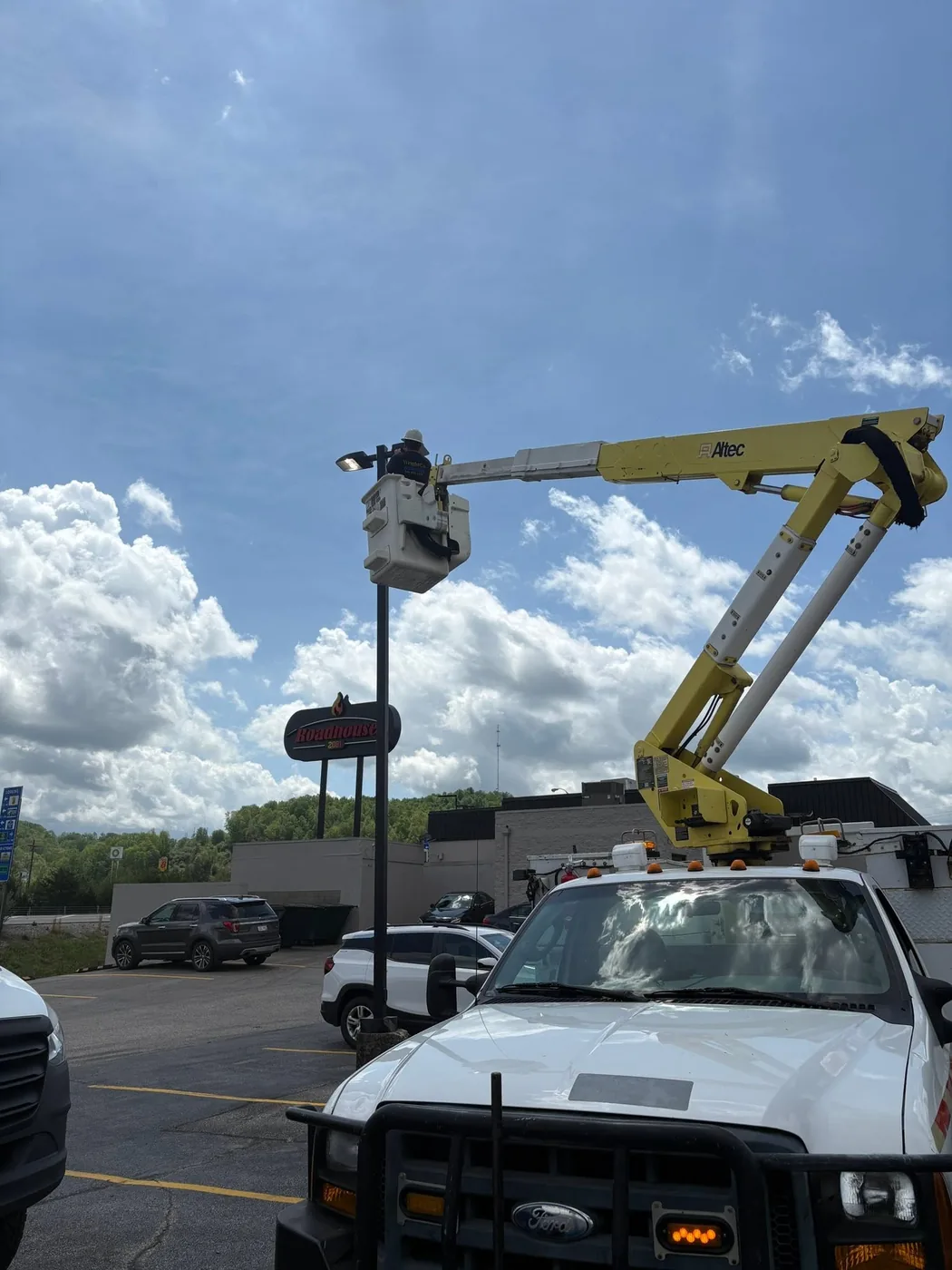 A Wright Co Electric aerial bucket truck raised against the sky
