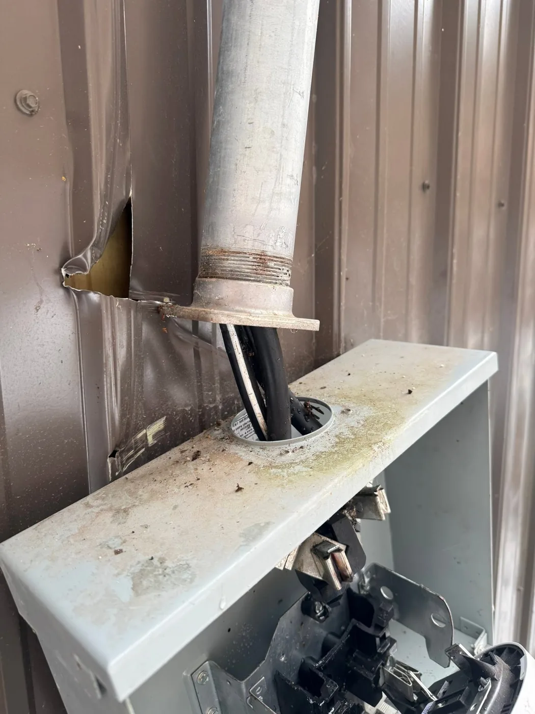 A metal flue and vent pipe running through a wall